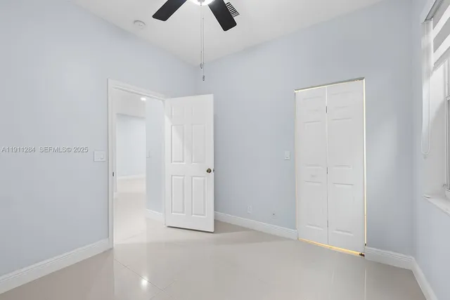 an empty room with chandelier fan