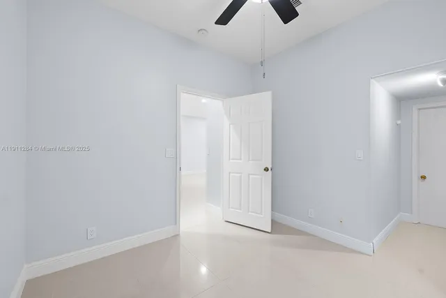 an empty room with chandelier fan