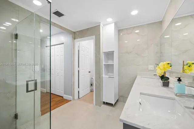 a bathroom with a granite countertop sink toilet and shower