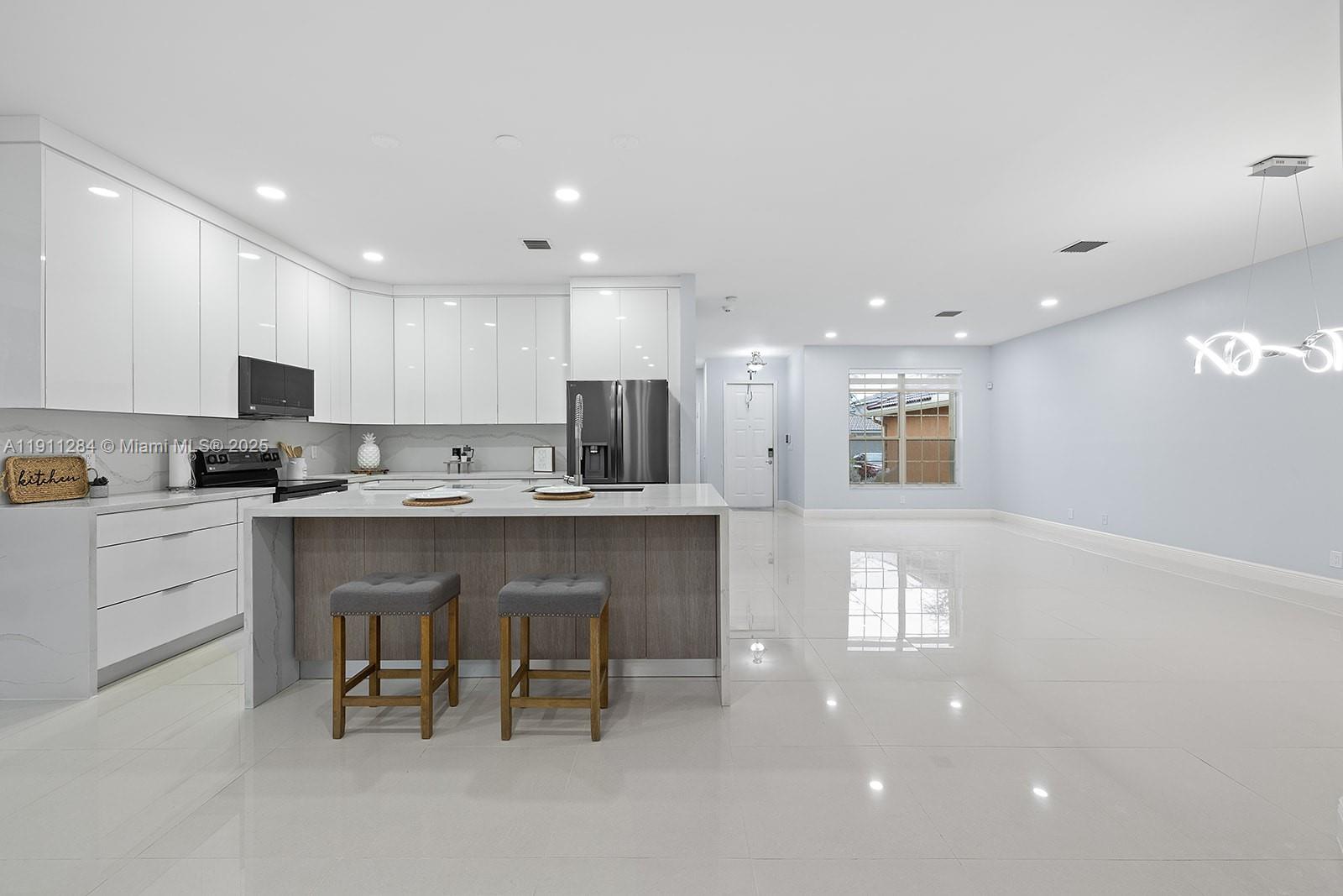 16296 Southwest 26th Street Miramar, FL 33027 - Photo 3 of 48 a kitchen with a refrigerator and a microwave
