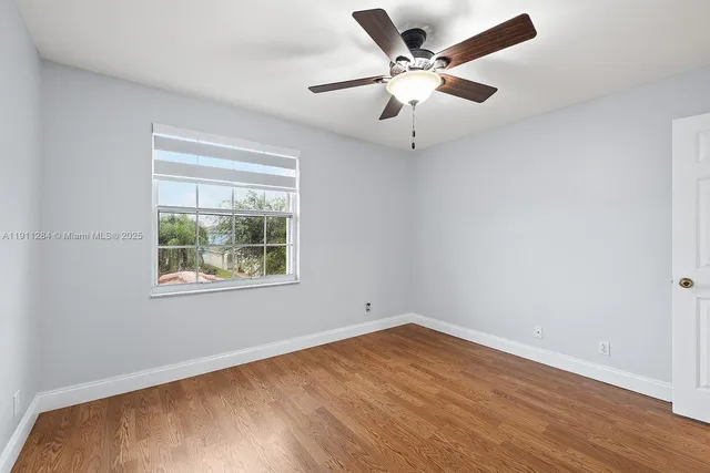 an empty room with a window and wooden floor