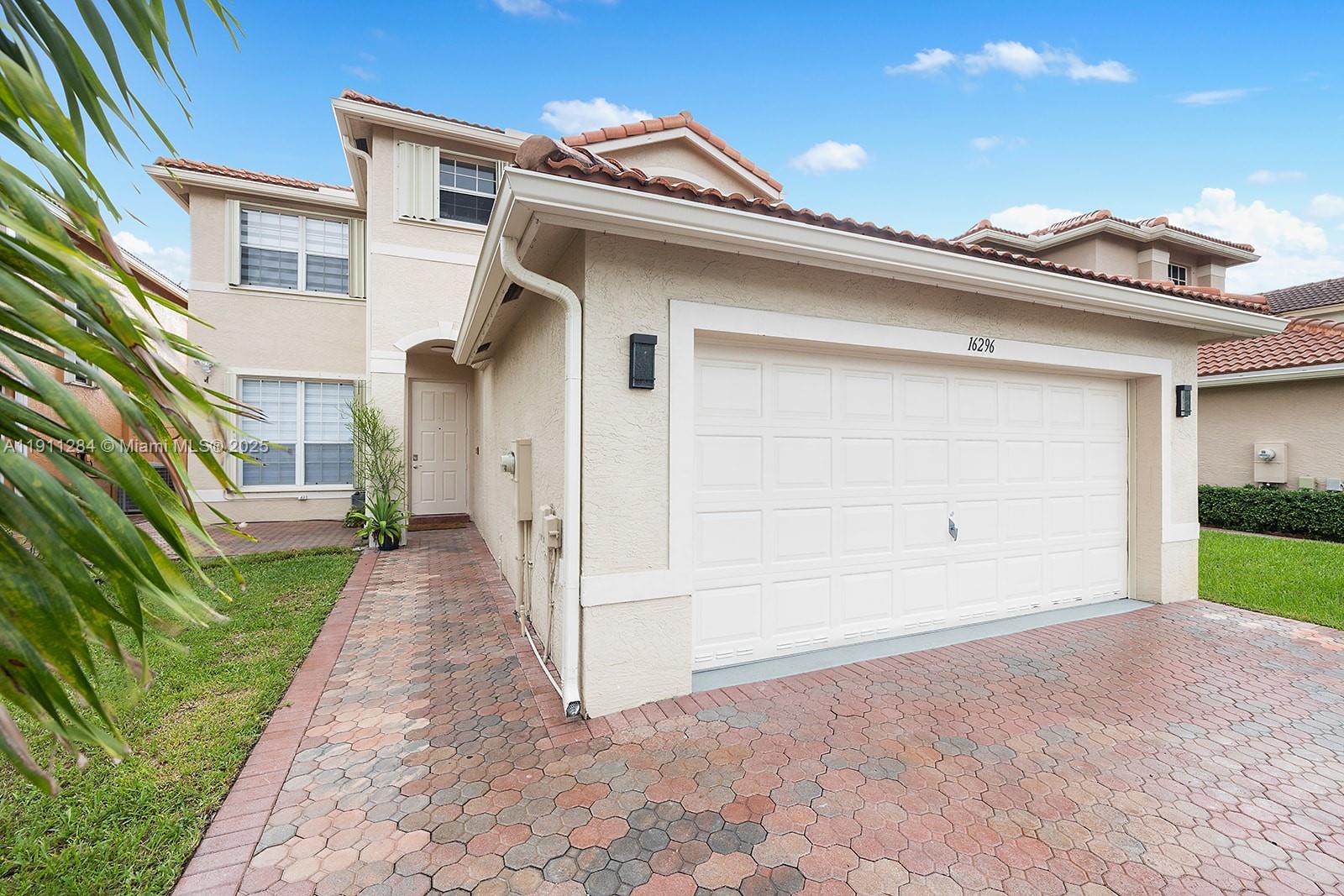 16296 Southwest 26th Street Miramar, FL 33027 - Photo 40 of 48 a view of a white house with a small yard and floor to ceiling window
