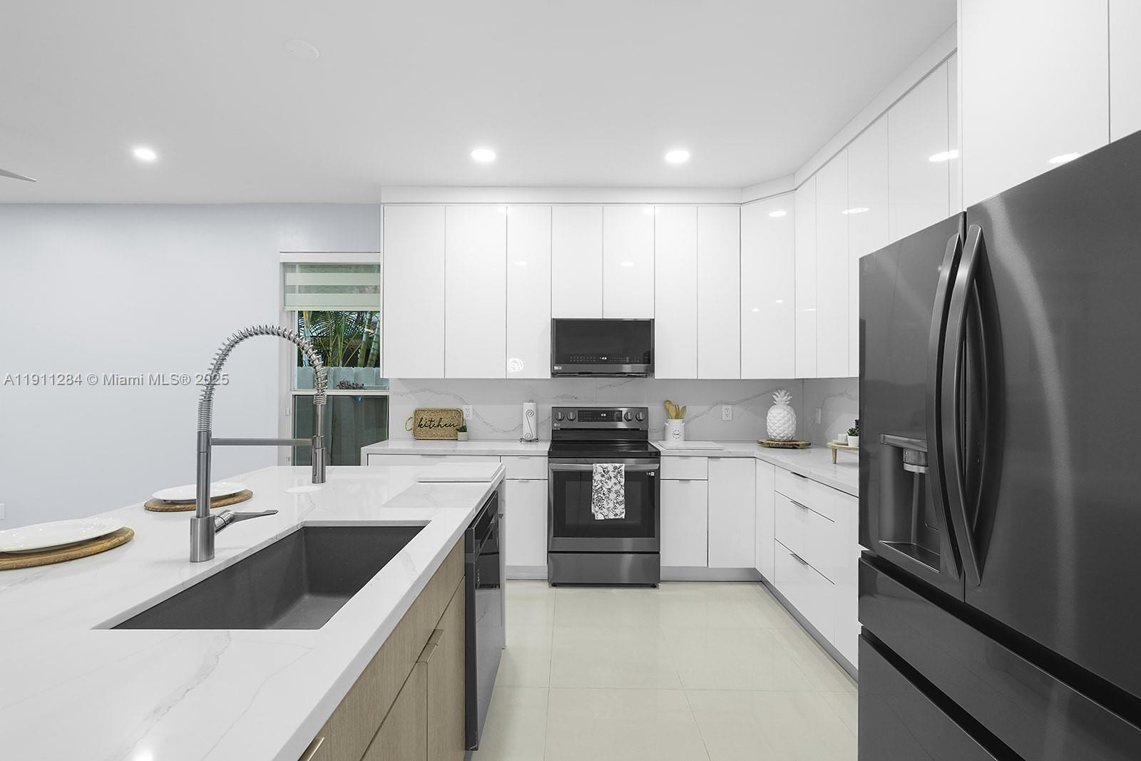 16296 Southwest 26th Street Miramar, FL 33027 - Photo 4 of 48 a kitchen with a sink stove and refrigerator