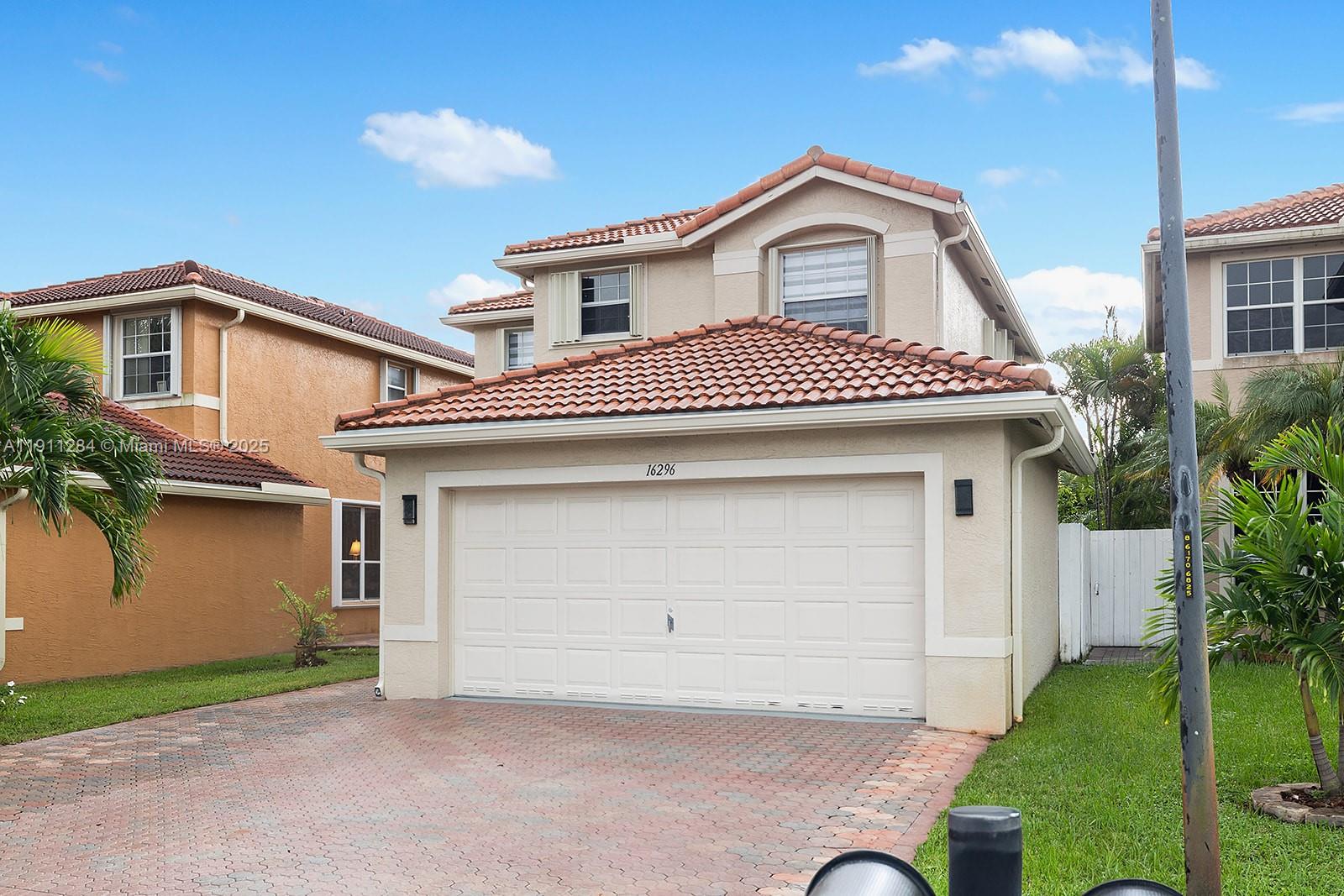 16296 Southwest 26th Street Miramar, FL 33027 - Photo 41 of 48 a front view of a house with a garden and garage