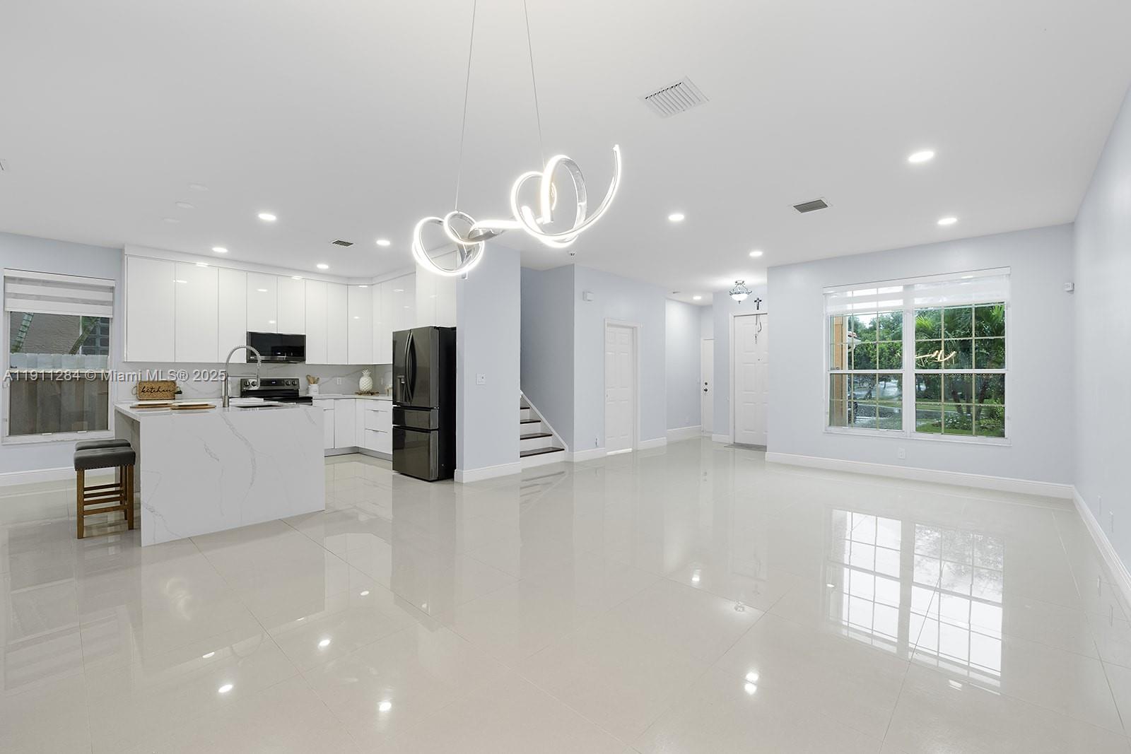 16296 Southwest 26th Street Miramar, FL 33027 - Photo 7 of 48 a view of a kitchen with kitchen island stainless steel appliances a window and a counter top space