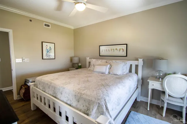 a bedroom with a bed a chair and painting on the wall