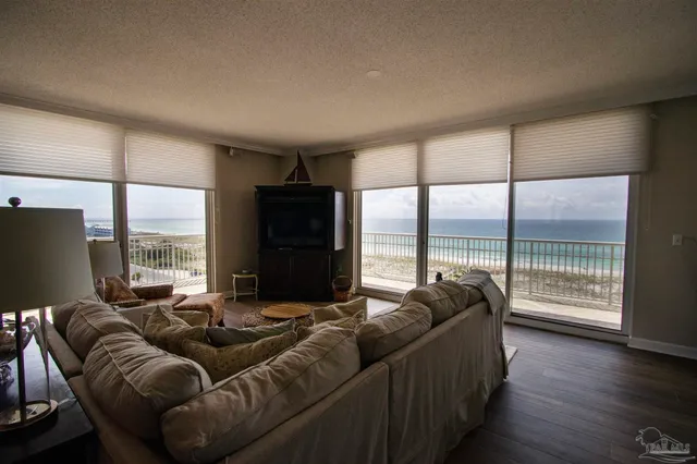 a living room with furniture tv and large windows