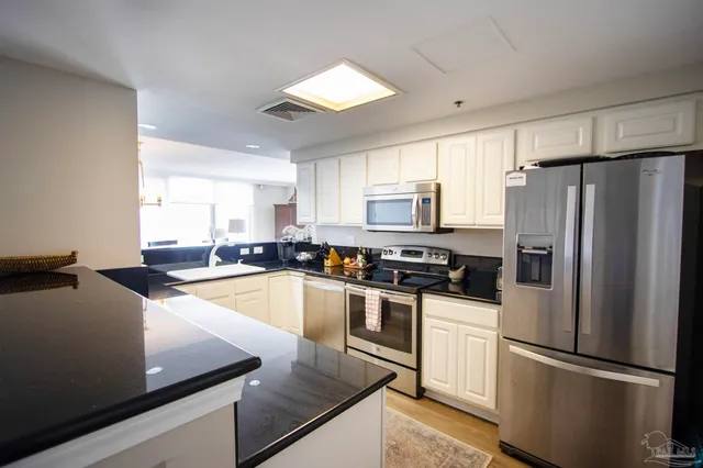a kitchen with granite countertop a refrigerator stove and sink