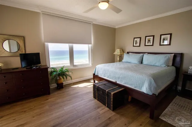 a spacious bedroom with a bed and a flat screen tv