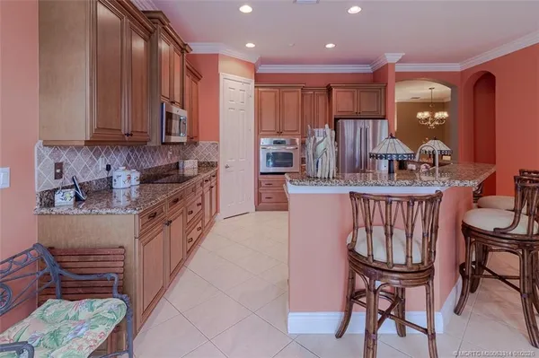 a kitchen with stainless steel appliances granite countertop a stove a sink a dining table and chairs