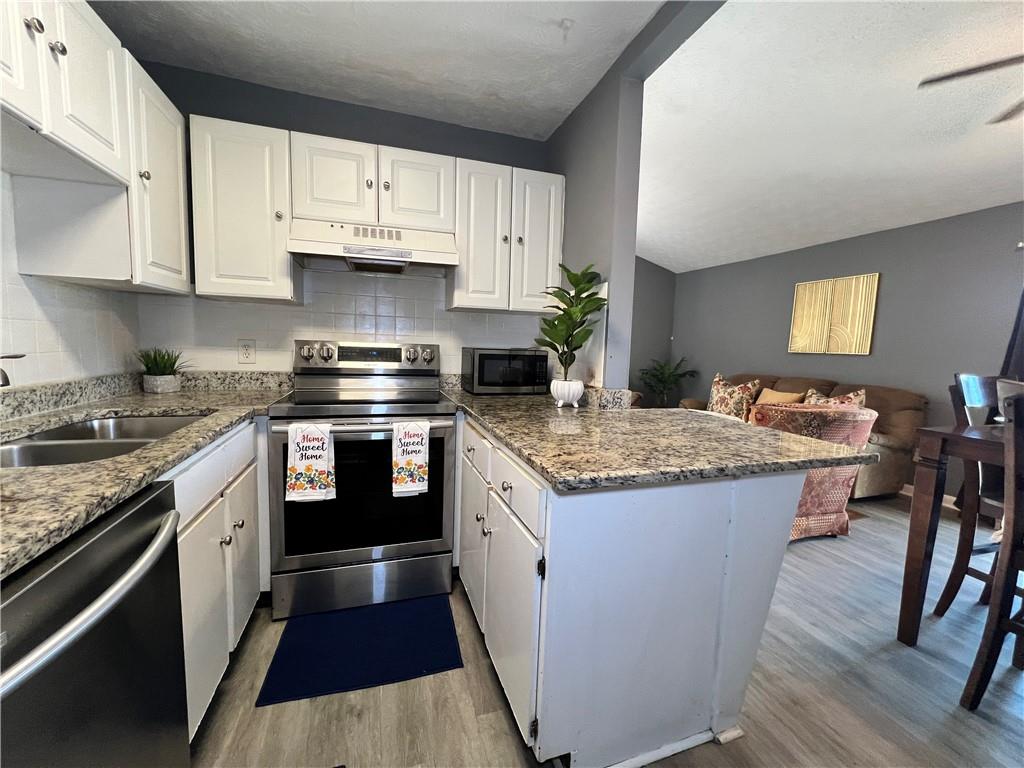 1496 Pine Log Road Northeast, Unit A Conyers, GA 30012 - Photo 20 of 24 a kitchen with stainless steel appliances granite countertop a stove and a sink