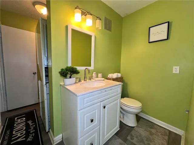 a bathroom with a granite countertop toilet sink and mirror