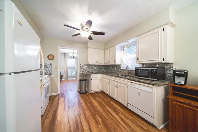 a kitchen with a sink stainless steel appliances a counter top space and cabinets
