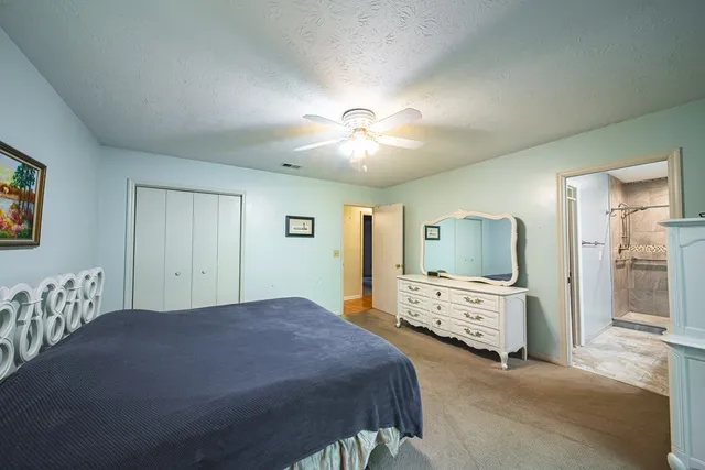 a spacious bedroom with a bed and a flat screen tv