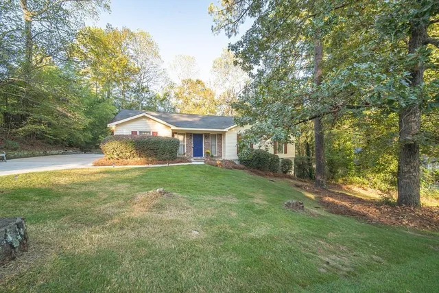 a front view of a house with yard and green space