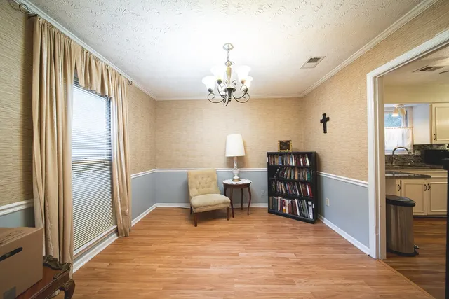 a view of a hallway with wooden floor and a cabinet