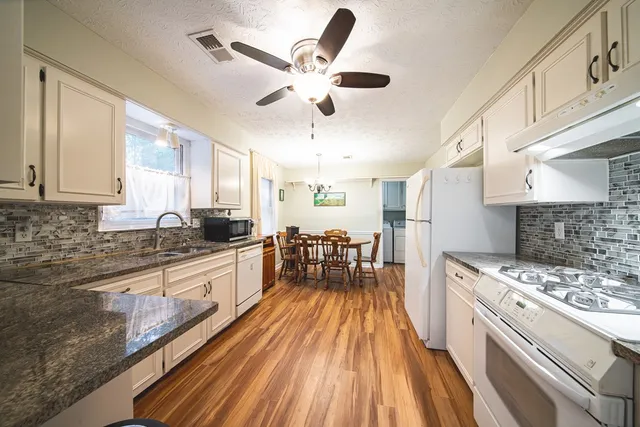 a large white kitchen with sink stove and refrigerator
