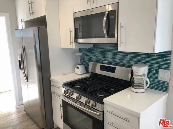 a stove top oven sitting inside of a kitchen