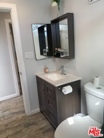 a bathroom with a sink vanity granite toilet and a mirror