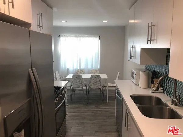 a kitchen with a table chairs refrigerator and microwave