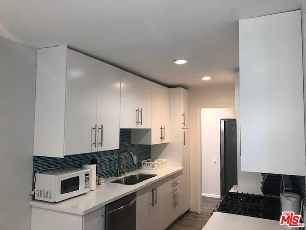 a kitchen with a sink cabinets and stainless steel appliances