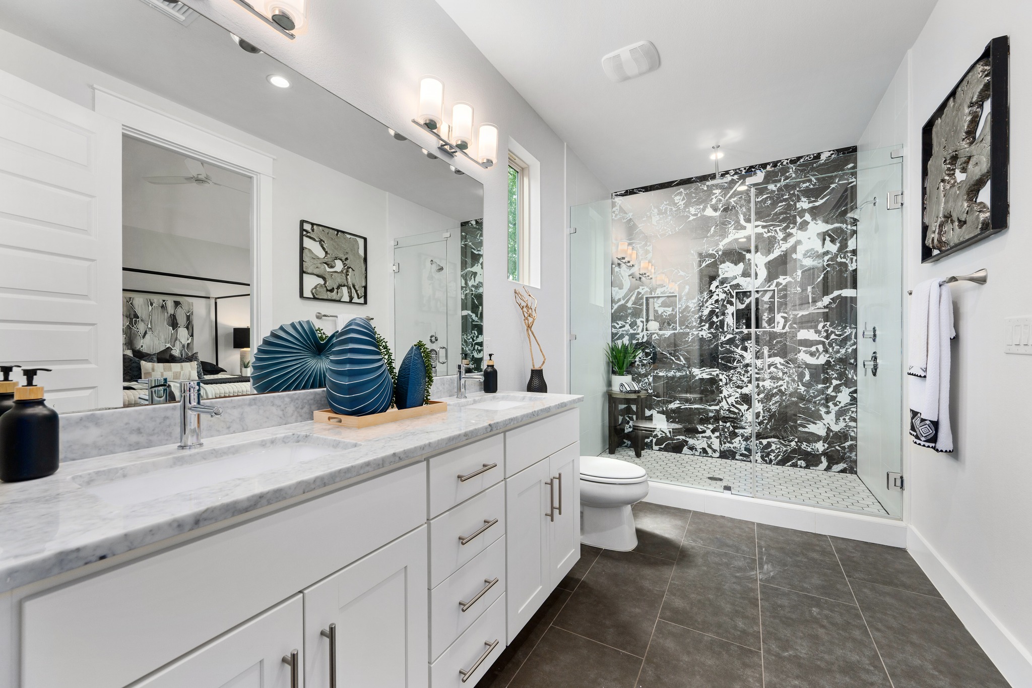 1409 Alegria Road, Unit A Austin, TX 78757 - Photo 14 of 24 Dual vanity with marble counters anchors a sleek bathroom, complete with a striking black and white tiled shower.
