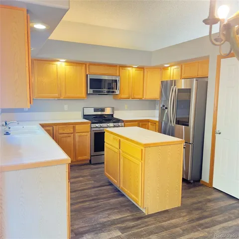 a kitchen with stainless steel appliances granite countertop a sink a stove and a refrigerator