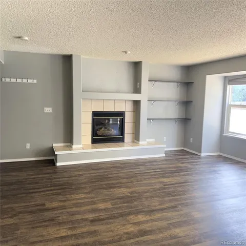 a view of an empty room with window and fire place