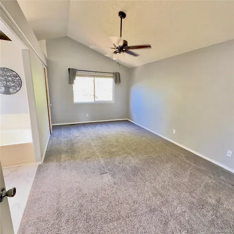 en empty room with windows and ceiling fan