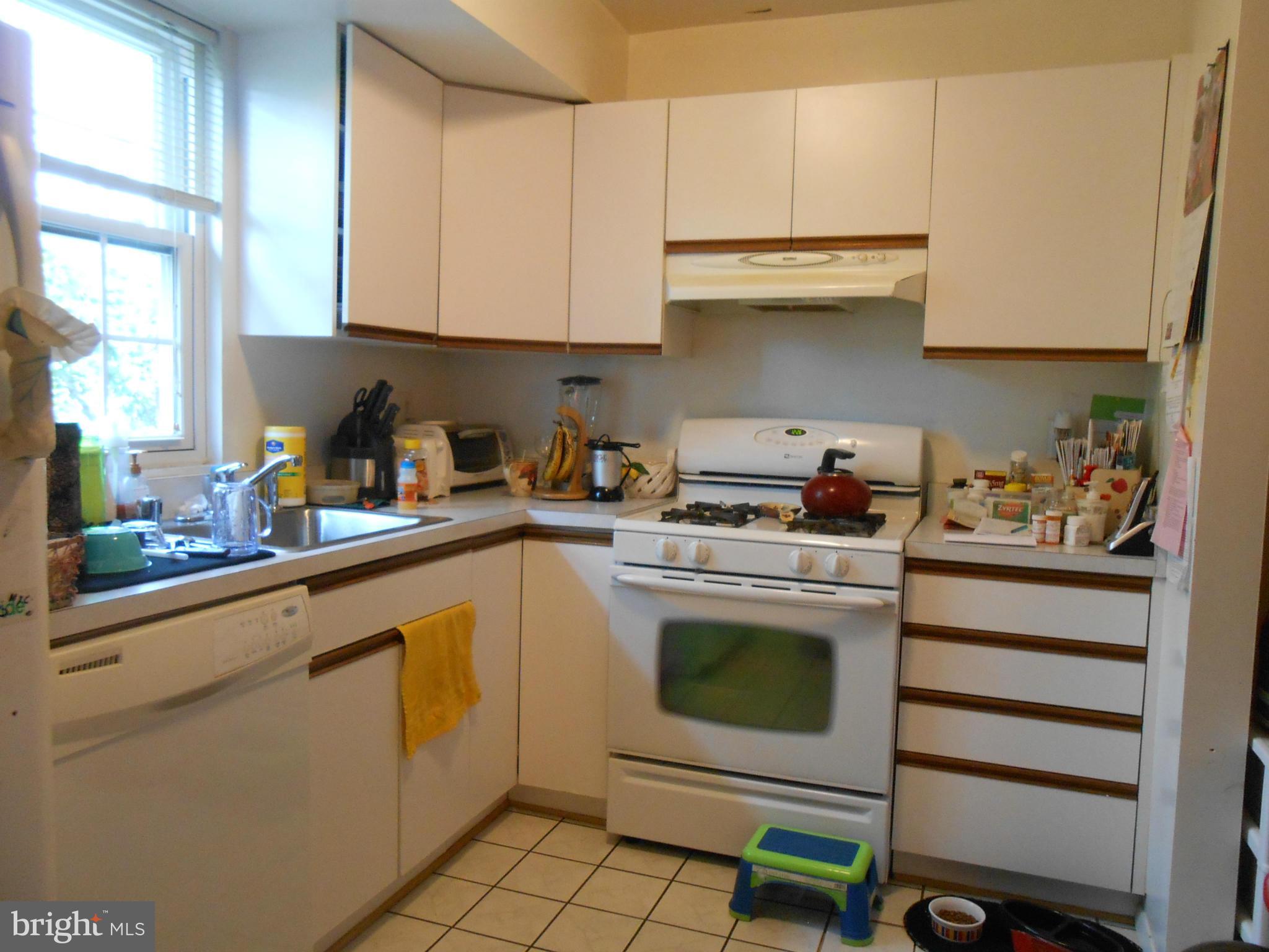 11917 Tarragon Road, Unit I Reisterstown, MD 21136 - Photo 3 of 9 a kitchen with a stove and white cabinets