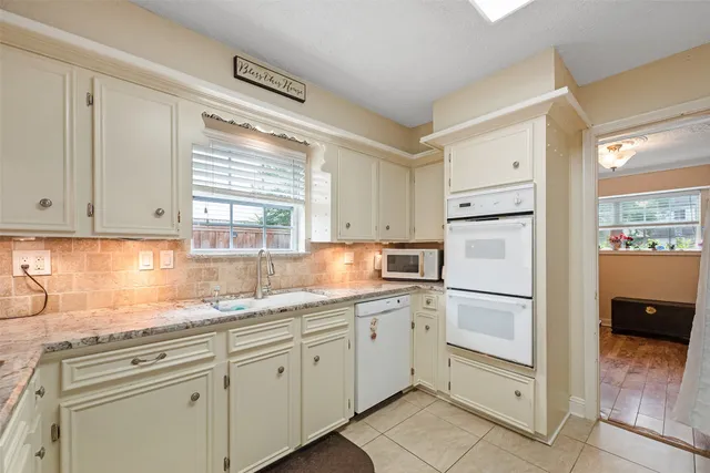 a kitchen with white cabinets and white appliances