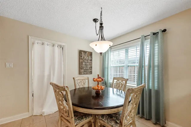 a dining room with furniture a chandelier and window