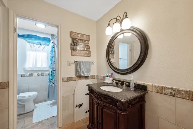 a front view of a house with a garden and trees