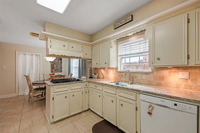 a kitchen with cabinets appliances a sink and a window