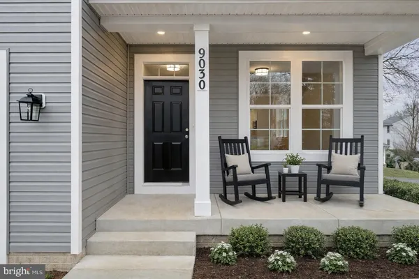 a front view of a house with glass windows and bench
