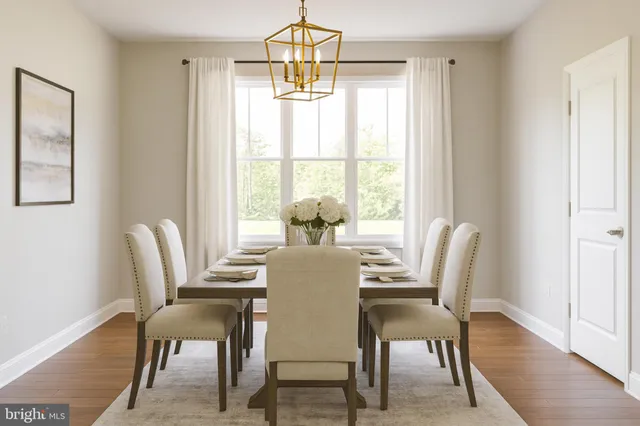 a dining room with furniture a chandelier and wooden floor