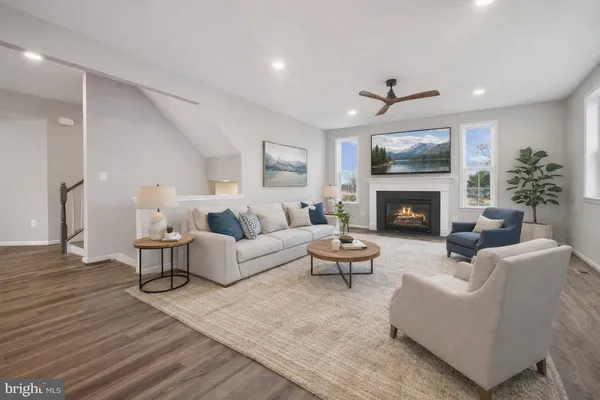 a living room with furniture a flat screen tv and a fireplace