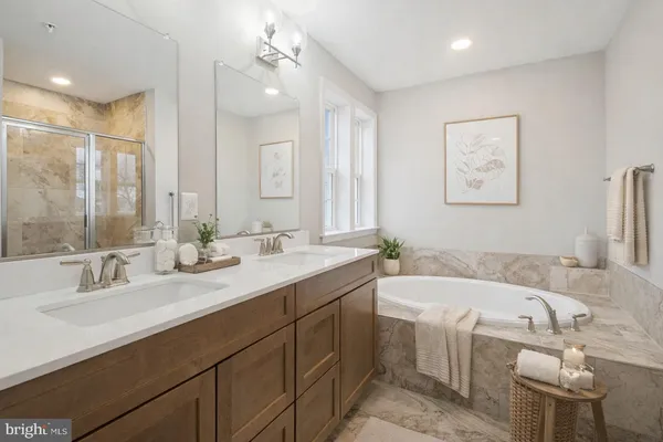 a bathroom with a tub sink and mirror