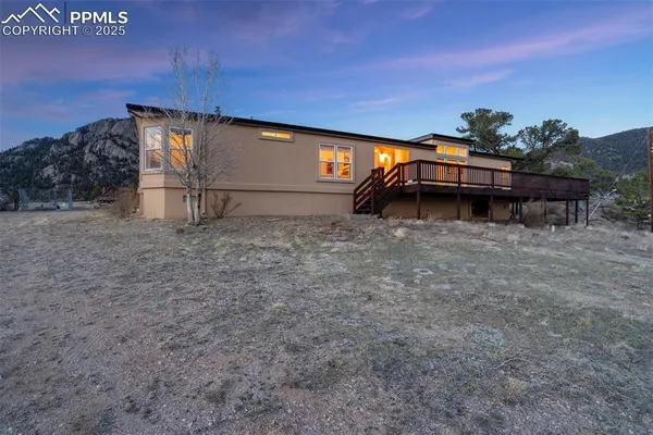 an aerial view of a house with a yard and mountain view