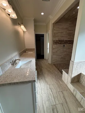 a bathroom with a granite countertop sink a toilet and shower