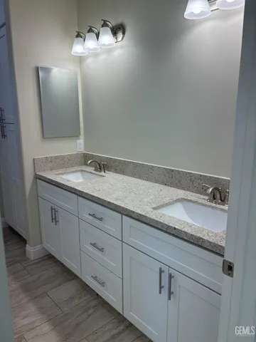 a spacious bathroom with a granite countertop sink and a mirror