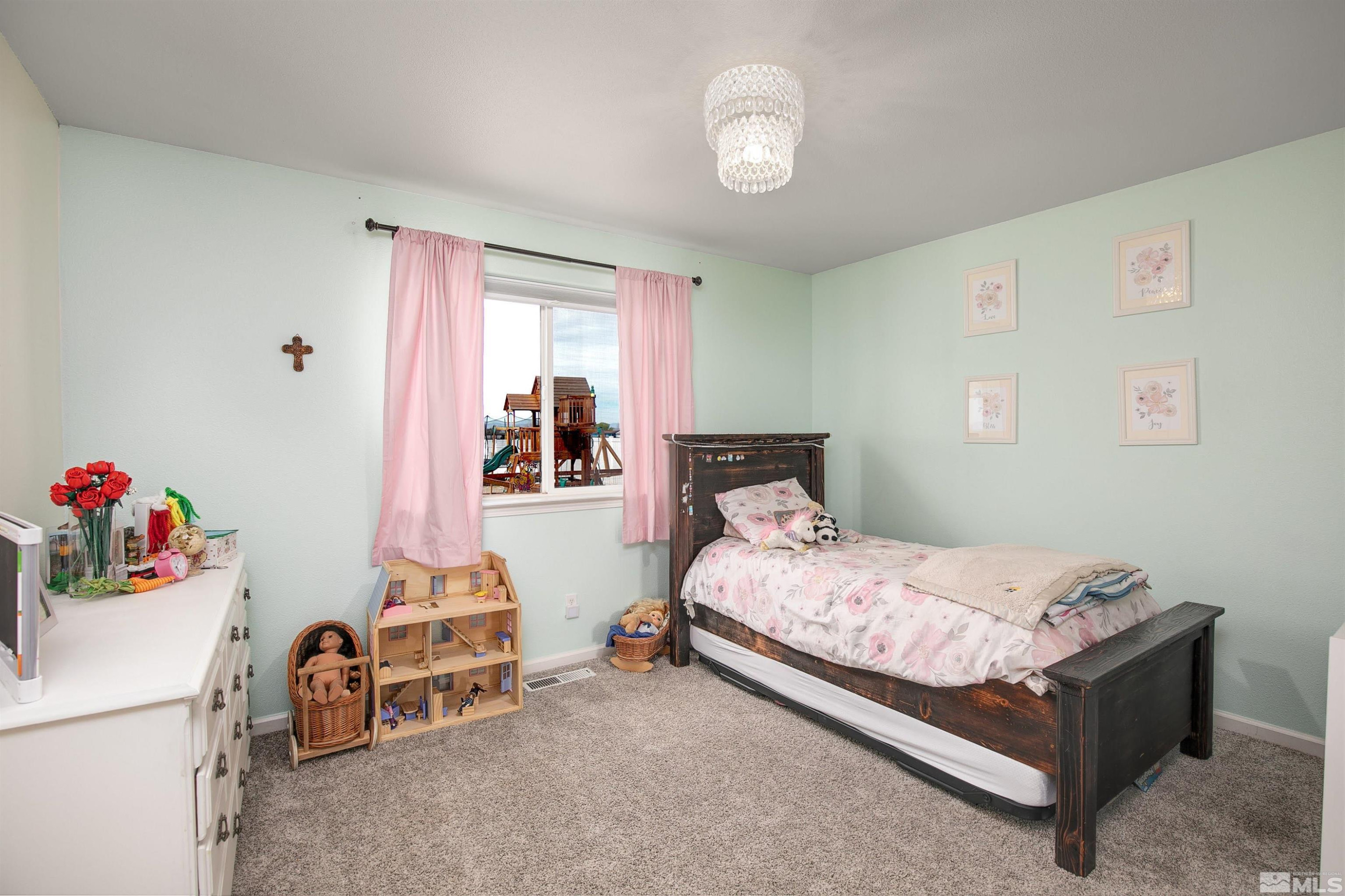 1675 Sky Ridge Drive Fallon, NV 89406 - Photo 13 of 31 a bedroom with a bed and a chandelier