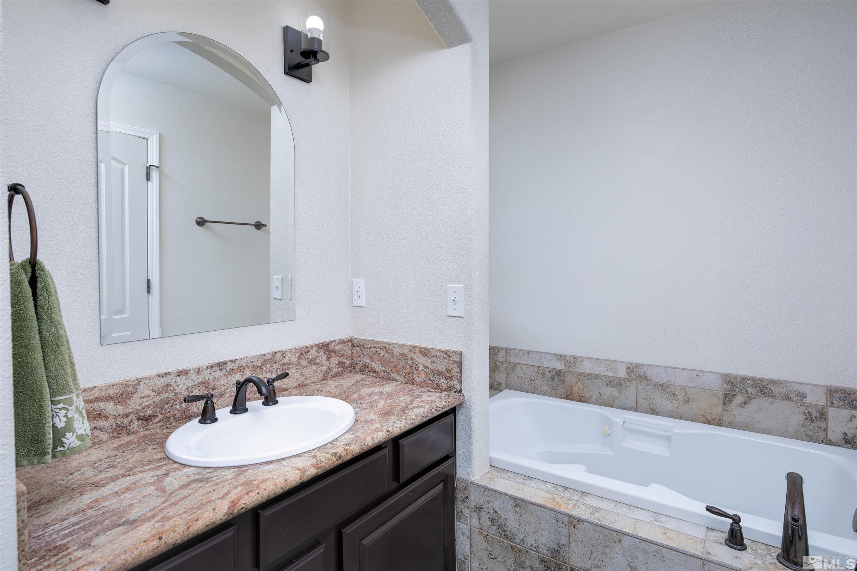 1675 Sky Ridge Drive Fallon, NV 89406 - Photo 19 of 31 a bathroom with a granite countertop sink and a mirror