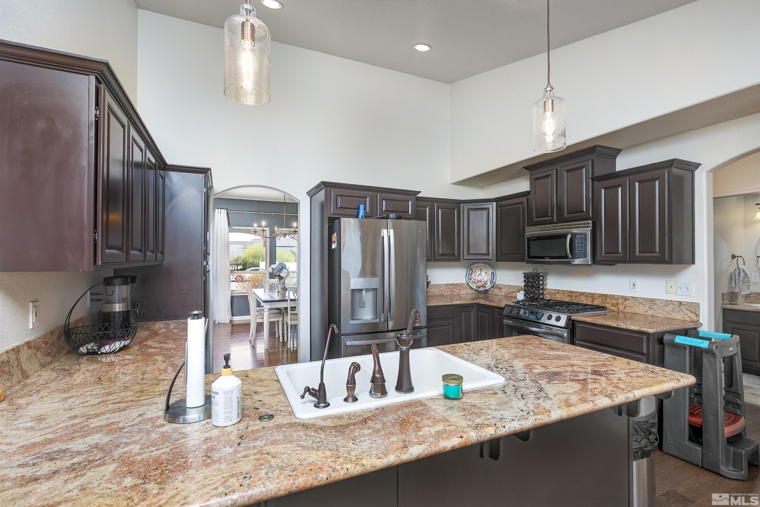 1675 Sky Ridge Drive Fallon, NV 89406 - Photo 8 of 31 a kitchen with kitchen island granite countertop a sink a counter space appliances and cabinets