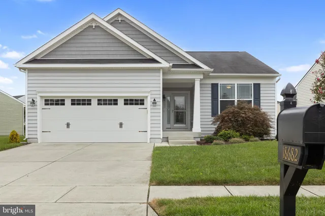 a view of a hallway with wooden floor and a bathroom