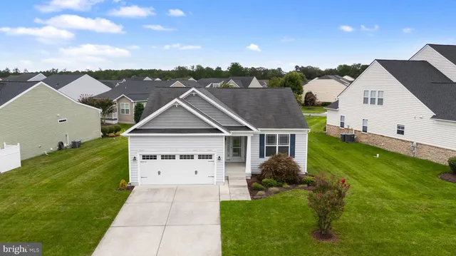 an aerial view of residential houses with outdoor space and trees