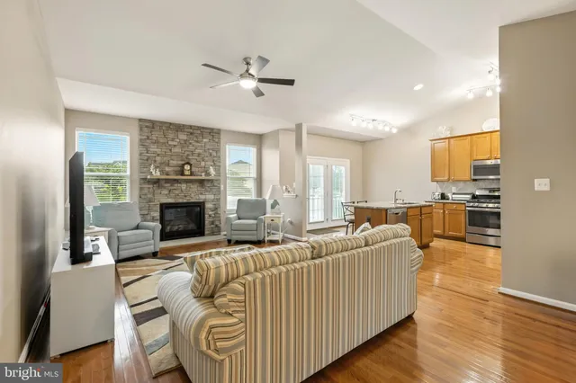 a living room with furniture kitchen view and a chandelier
