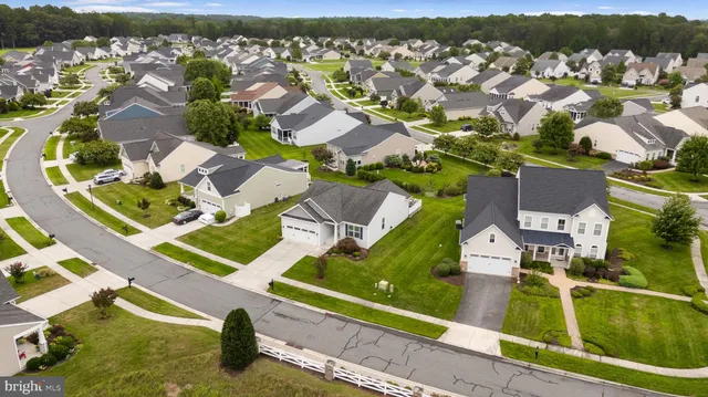 an aerial view of residential houses with outdoor space and parking