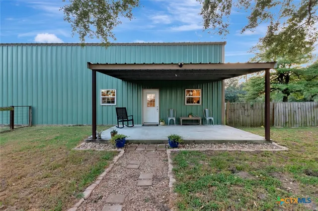 a view of a house with backyard and sitting area