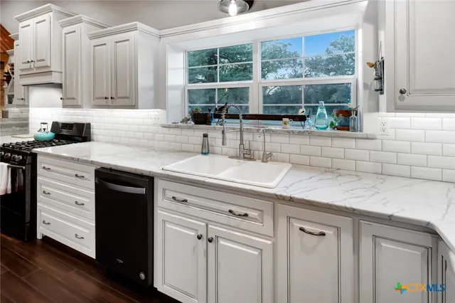 a kitchen with stainless steel appliances granite countertop a sink a stove and cabinets